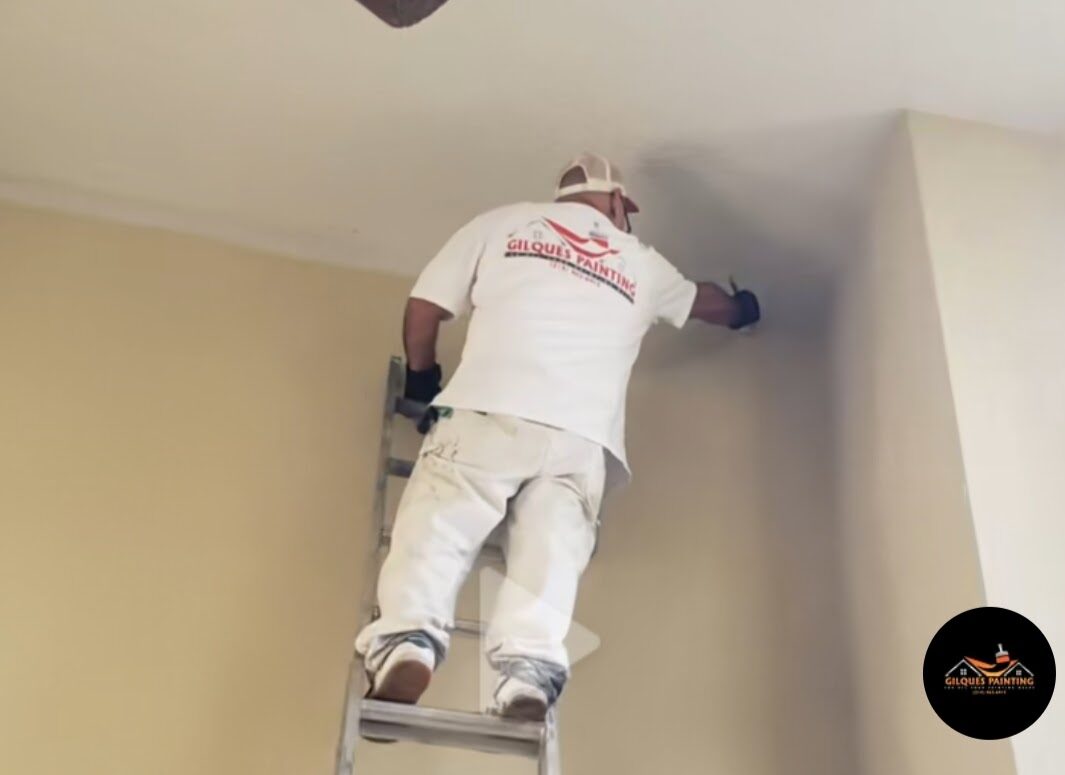 Painter on ladder — interior wall repaint