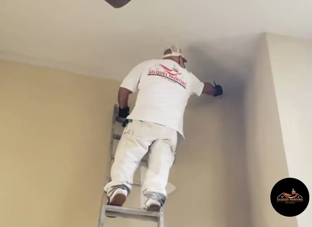 Painter on ladder — interior wall repaint