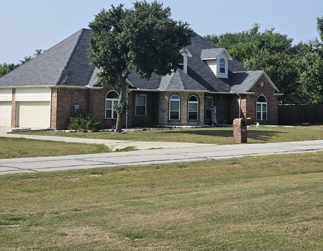 Painted stone-front home with driveway